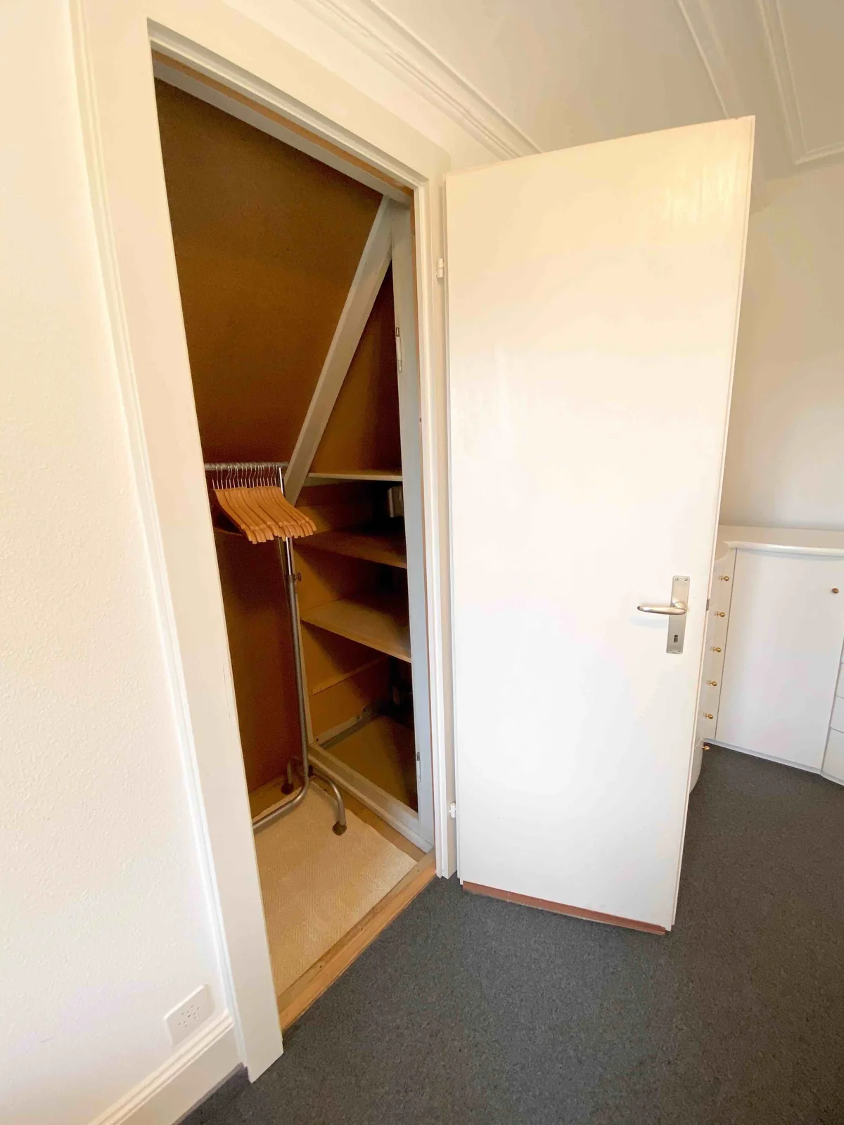 Schlafzimmer Ost – Garderobe mit Kleiderstange und Regalen